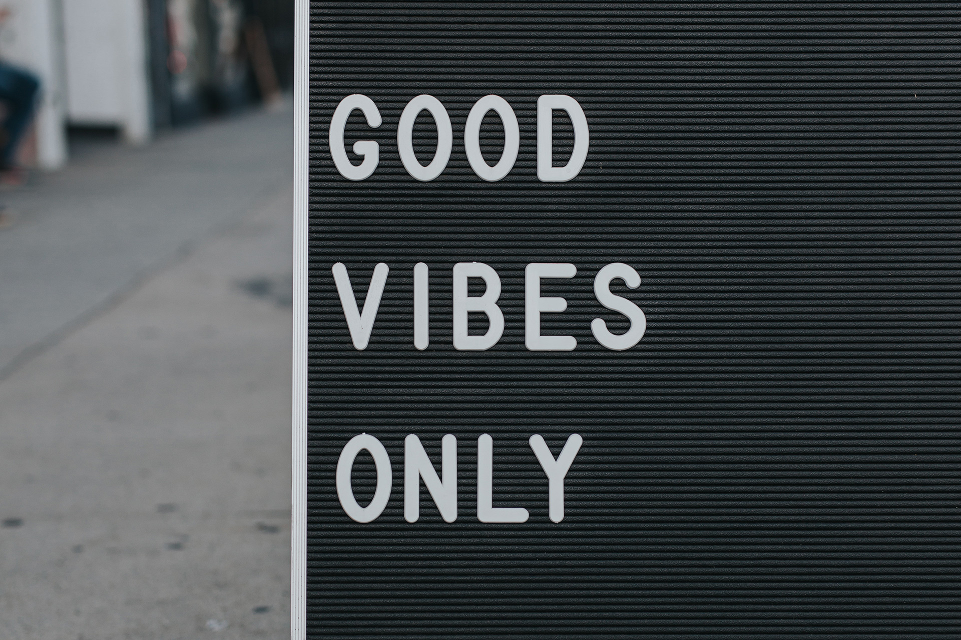 Signboard standing on the street with a sign that says Good Vibes Only.