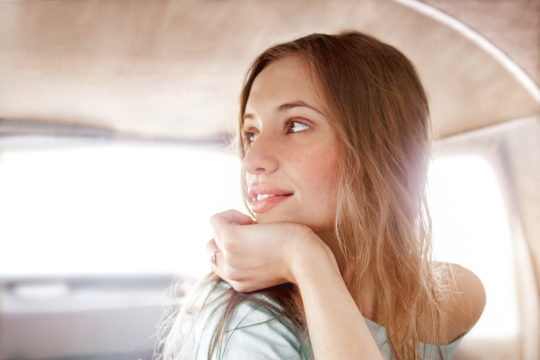 Girl sitting in a car looking out the window