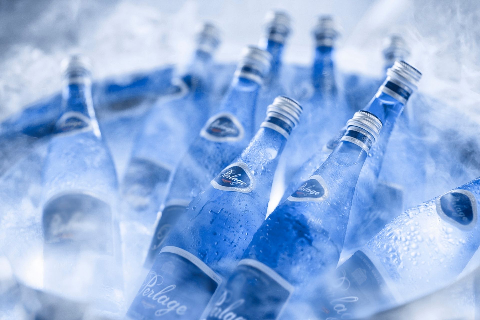Close up shot of chilled water bottles in a ice bucket